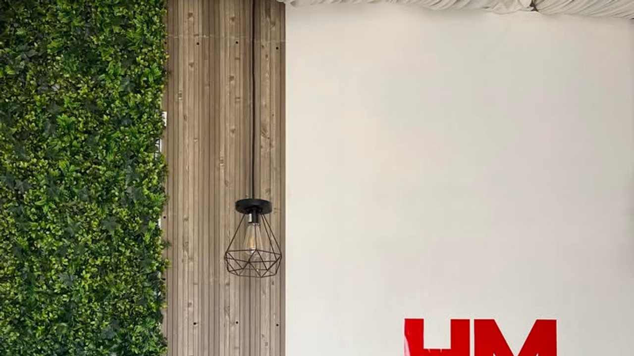 Muro verde, madera y lámpara del estudio HM Studio